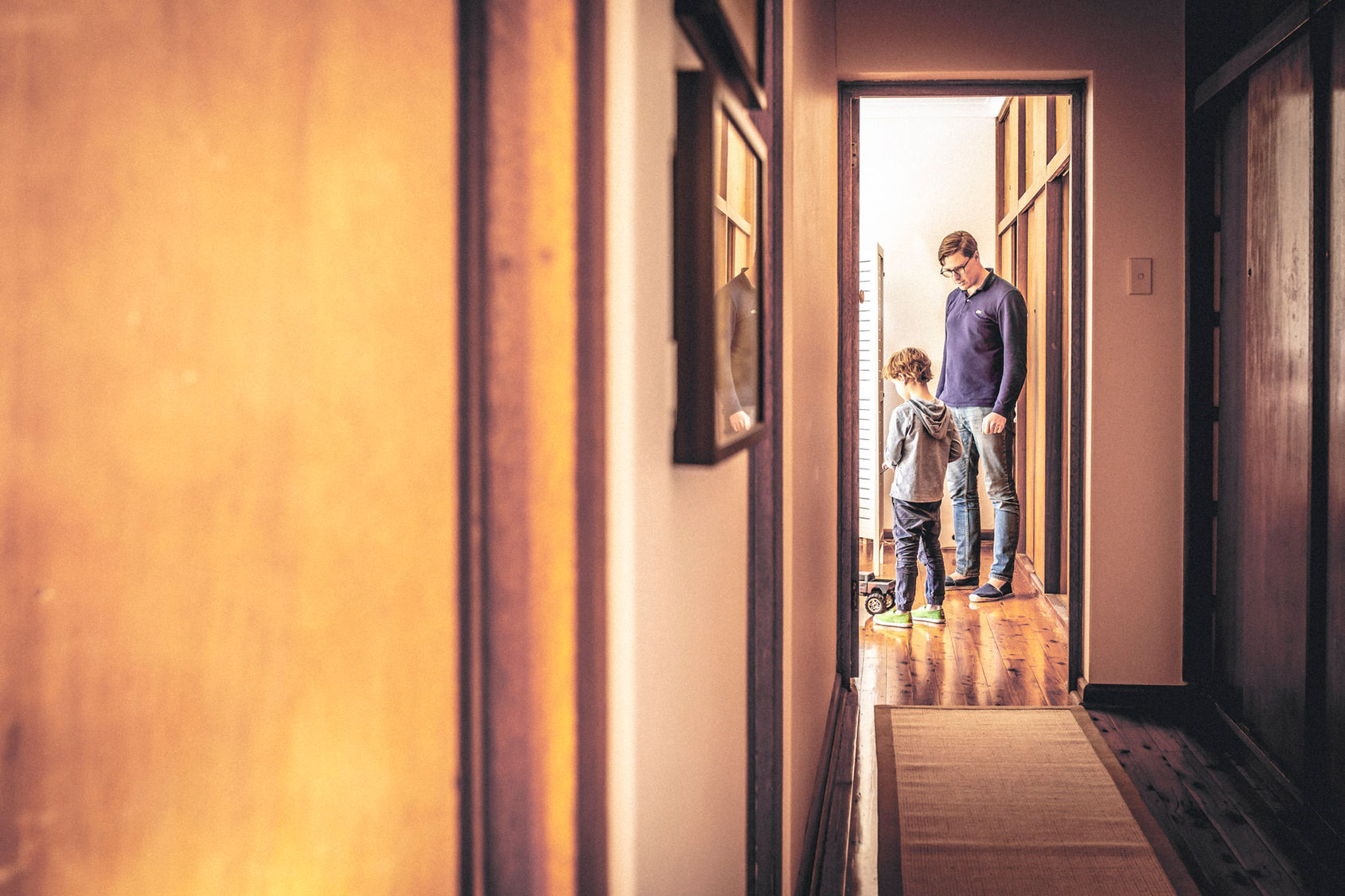 Family photography Suzanne Stevenson. Authentic phot of Dad and his son at home playing with remote control car