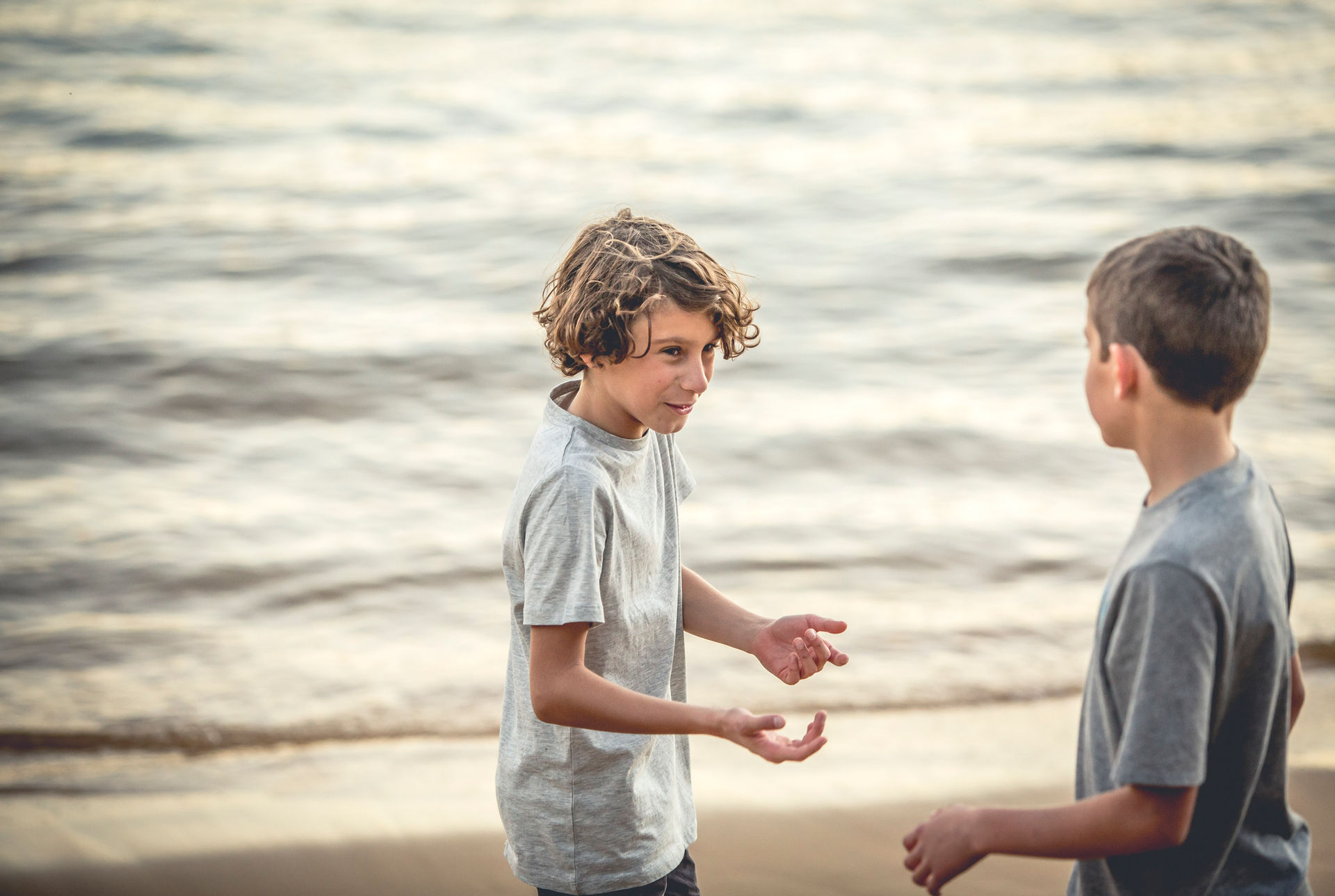 Two boys playing at sunset at Manly beach. Family Photographer Suzanne Stevenson Mosman Sydney