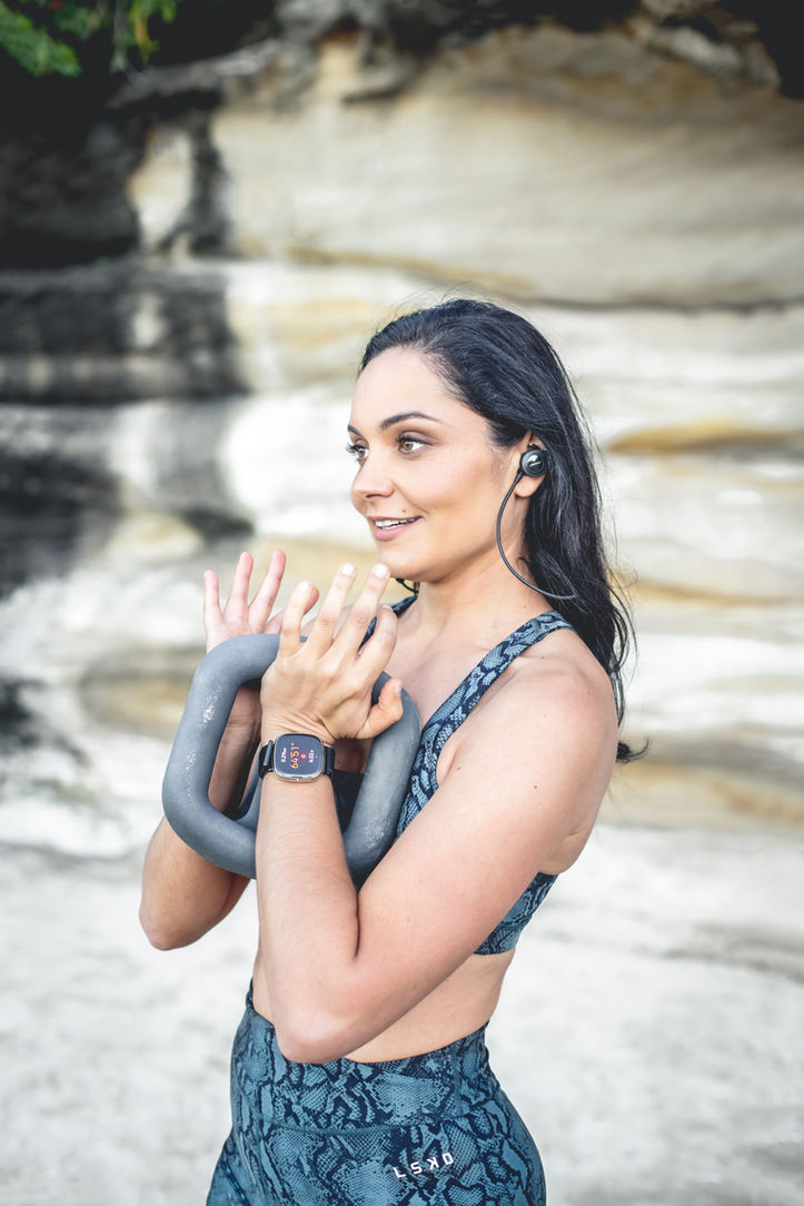 Woman holding weights doing a workout outdoors for personal brand photo shoot. Personal Branding photo shoot for health coach. Photographer Suzanne Stevenson 