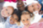 Closeup face of happy multiethnic children embracing each other and smiling at camera. Tea
