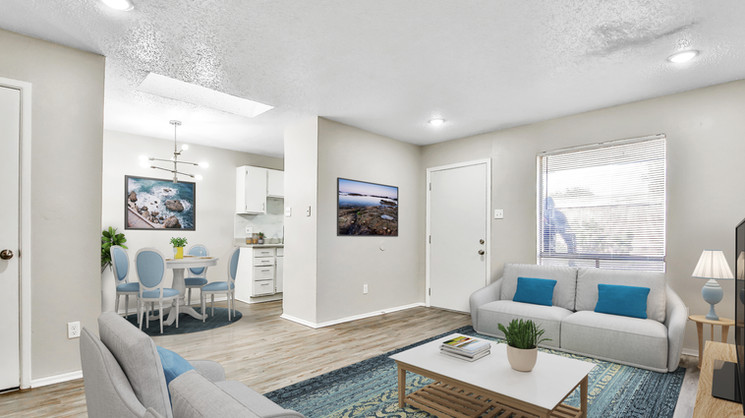Open-concept living room with recessed lighting, skylight, natural light, and luxury vinyl plank flooring at Lubbock Heights Apartments in Lubbock, TX.