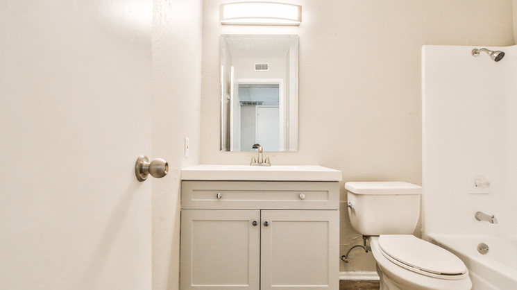 Updated bathroom with vanity cabinet, sink, and shower at Lubbock Heights Apartments in Lubbock TX.