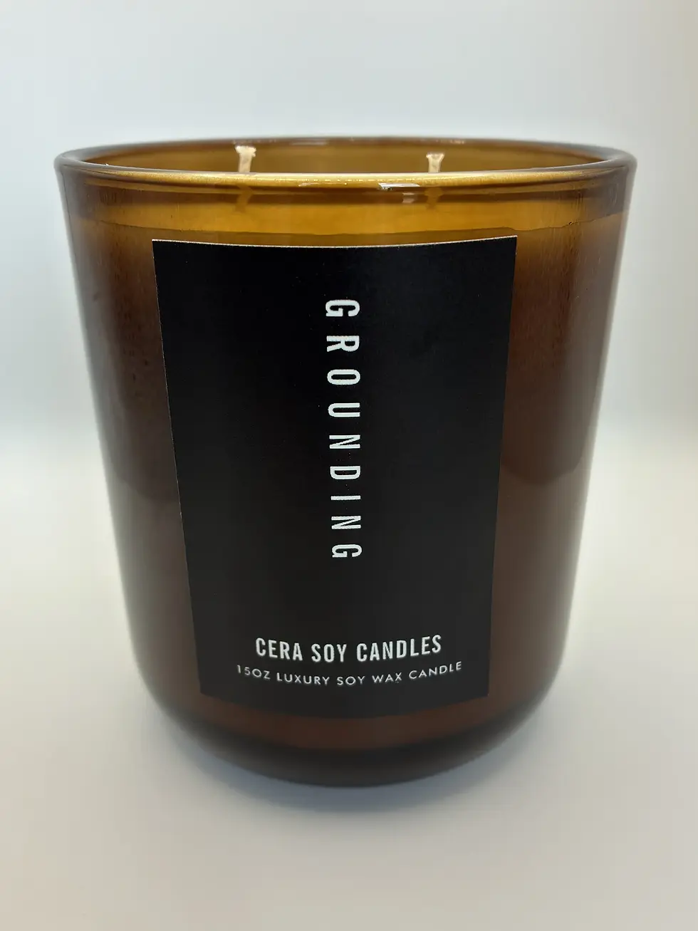 Grounding soy candle in an amber glass jar with a black label