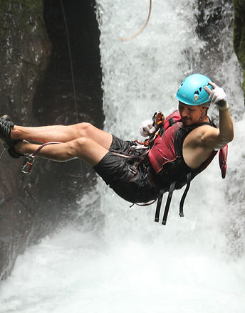 man suspended over a waterfall