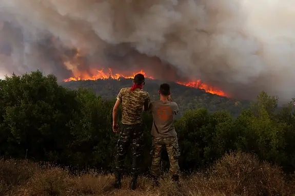 Two men looking at a huge fire in Alexandroupolis, Greece on August 2023