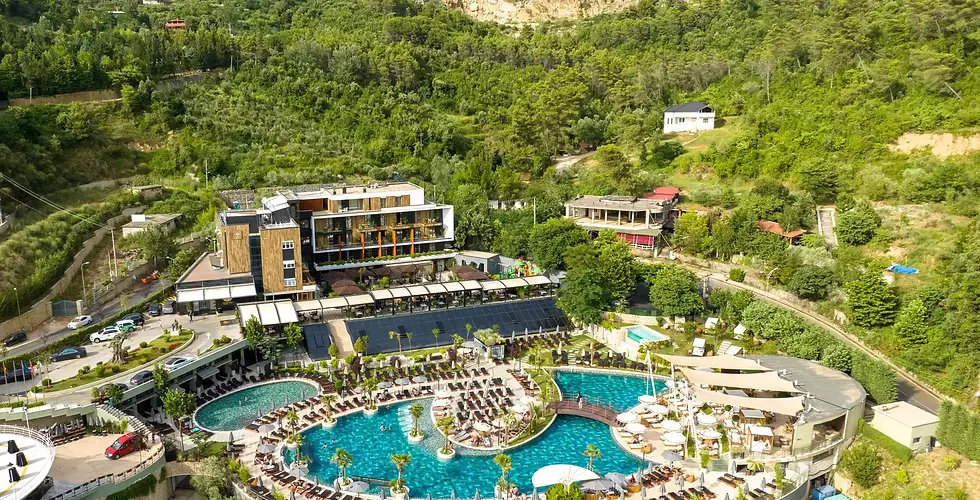 Aerial view of Select Hill Resort Tirana with outdoor pools and mountain landscape.