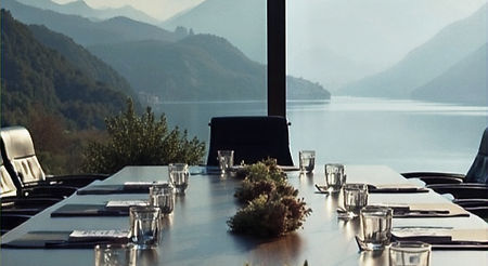 Outdoor conference setup and corporate incentive lunch with a long dining table overlooking a scenic mountain lake in Albania