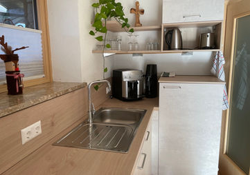 Moderne Küchenzeile in einer Ferienwohnung mit Spüle und Kaffeemaschine