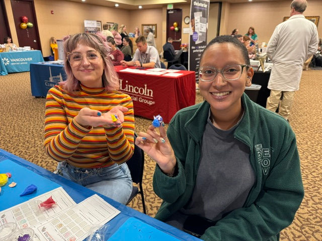 Two proud participants display their artwork created at their company wellness fair.