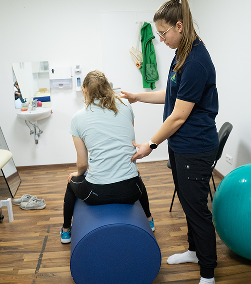 Therapeutin hilft einer Patientin bei einer Übung