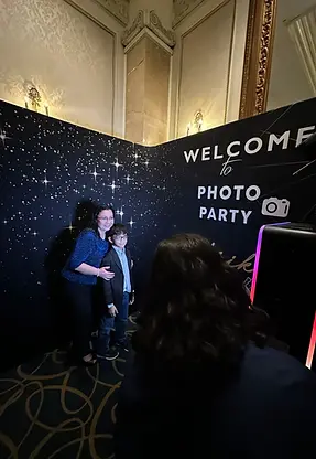Woman and child at 'WELCOME to PHOTO PARTY' photo booth