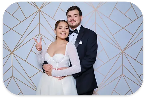 Smiling couple in wedding attire, woman shows peace sign