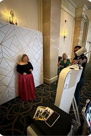 Woman in red skirt posing at a geometric photo booth backdrop