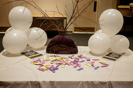 Table with book, candy, white balloons and a vase