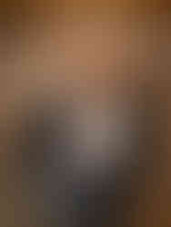 Direct flash indoor brewery engagement photo of couple sitting at fireplace enjoying drinks