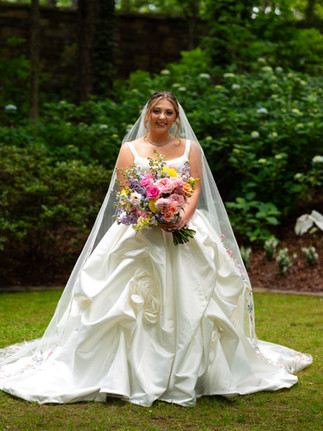 Spring wedding bridal portrait, showing colorful bouquet and princess ball gown style wedding dress