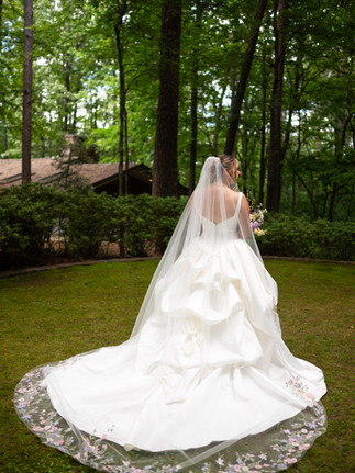 Portrait showing textured wedding gown detail and floral veil