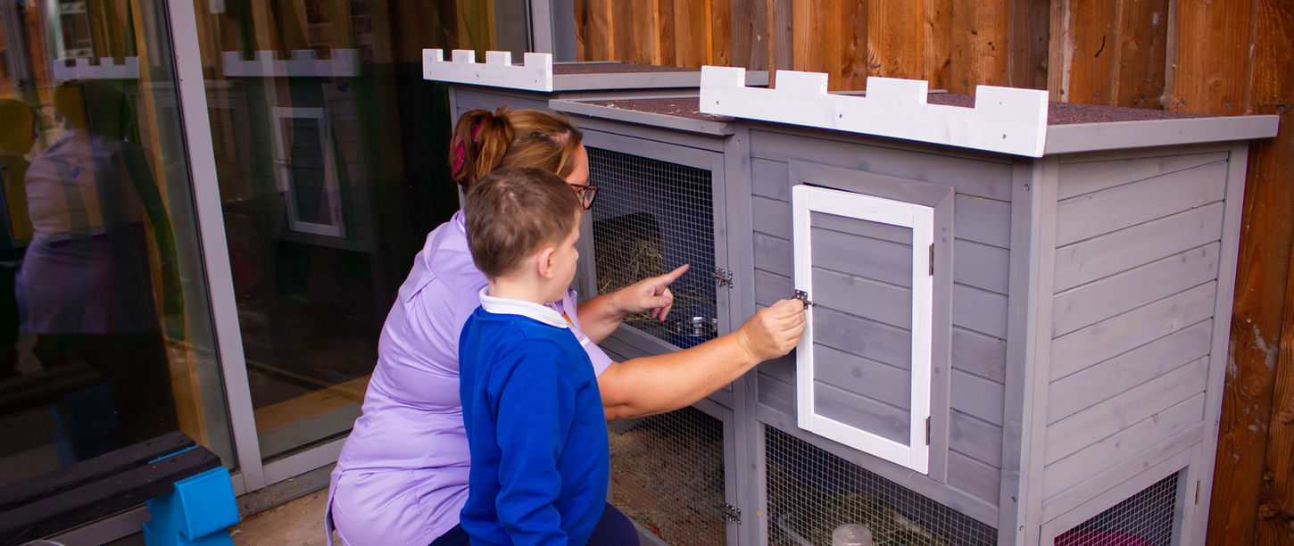 Staff member and child with a rabbit.