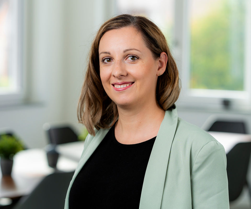 Mitarbeiterbild vor einem Konferenzraum im Unternehmen