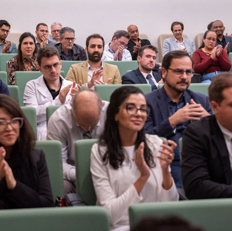 Público aplaudindo palestrante em simpósio