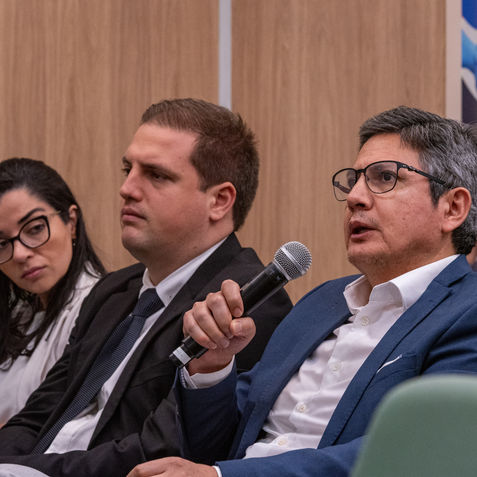 Palestrante falando ao microfone em simpósio