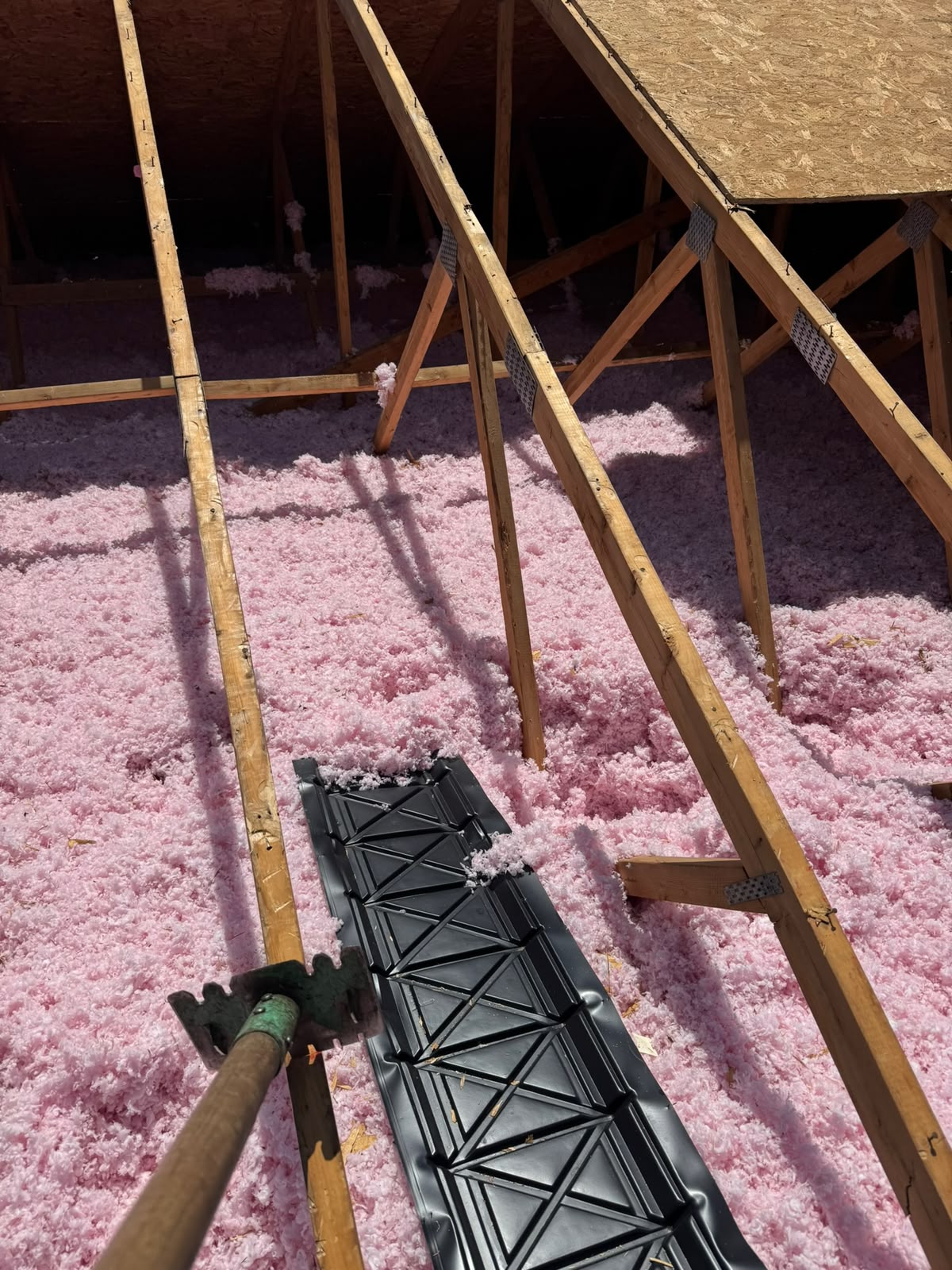 Insulation and a ventilation baffle between attic framing