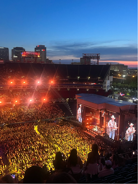 Concert stage with red lights and a full audience watching the concert.