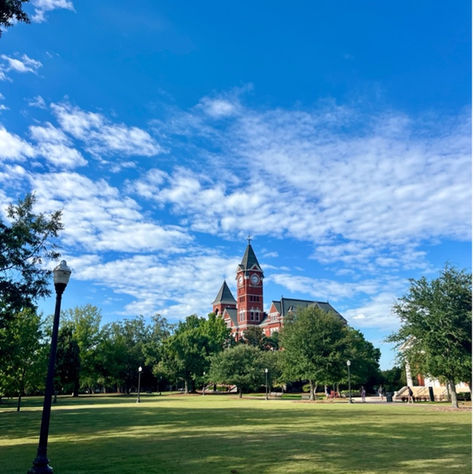 samford hall under blue sky with clouds surrounded by green trees