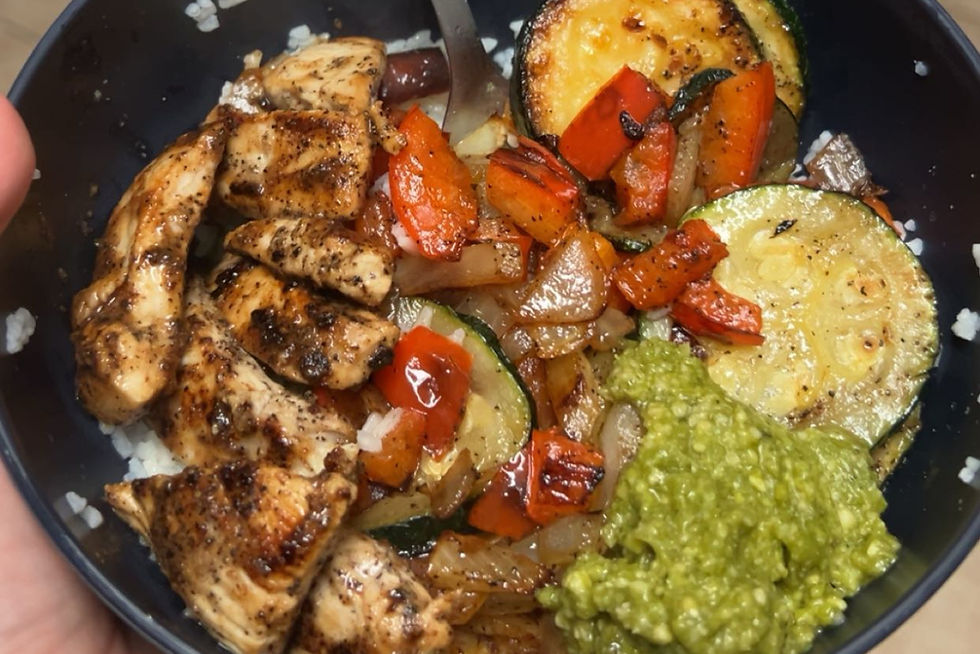 Grilled chicken, red peppers, zucchini, and guacamole in a bowl. Vibrant colors with a rustic, appetizing presentation.