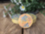 Thumbnail: A top-down view of three round Baby Bliss artisan soap bars with vibrant blue and pink swirls against a pale yellow base. The