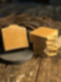 Thumbnail: Handcrafted Oatmeal Honey Draft soap bars displayed on a rustic wooden surface, with one bar standing upright to show its tex