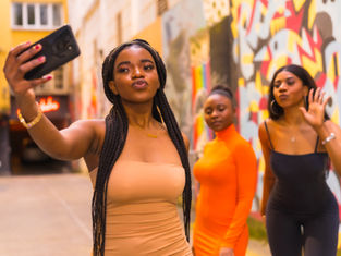 African social media creator recording a video using a smartphone and ring light.