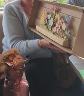 Handgemaakt bloembeeld in cadeauverpakking, vastgehouden als uniek en persoonlijk verjaardagscadeau