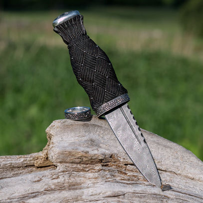 Traditional Scottish Sgian Dubh with carved Bog Oak handle, Sterling Silver fittings, engraved lower ferrule and patterned steel blade.
There is a matching ring engraved with the same design as on the lower ferrule of the Sgian Dubh.