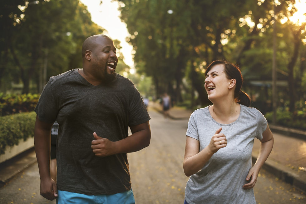 African American man and white woman happily jogging and reducing stress.
