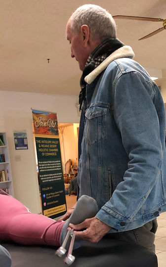 Glenn doing sound therapy on a woman's foot