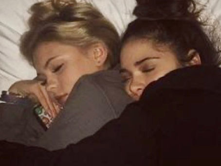 two women cuddling in bed, in profile