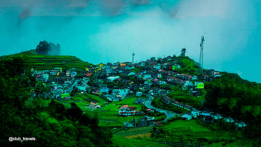 Scenic village landscape with houses on a lush green hill and towers