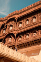 Intricate wooden building facade with windows against blue sky background.