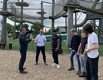 Staff are undergoing training near a high ropes course 