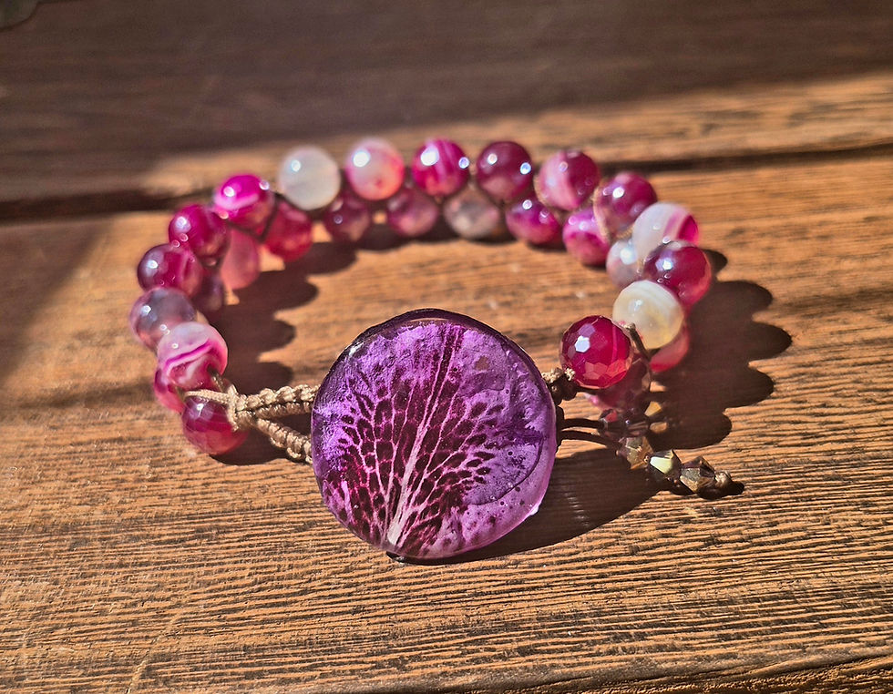 A full, elegant view of the handmade magenta and plum agate bracelet, highlighted by the striking rhododendron petal button