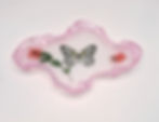 A handcrafted resin vanity tray with a pink border, featuring real pressed flowers and a decorative butterfly