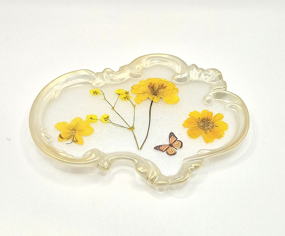 A handcrafted resin vanity tray with a gold border, featuring real pressed flowers and a decorative butterfly