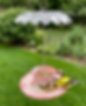 Handcrafted vintage-style teacup and saucer bird feeder with floral patterns and 'Amour' script, hanging in a lush backyard