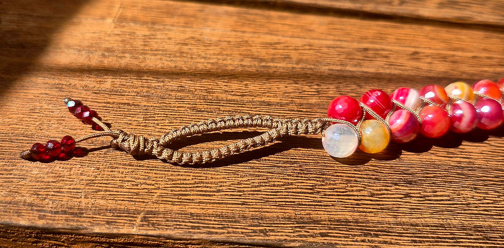 Thumbnail: A close-up view of the adjustable cord closure and loop on a beaded bracelet, showing faceted red and orange agate stones.
