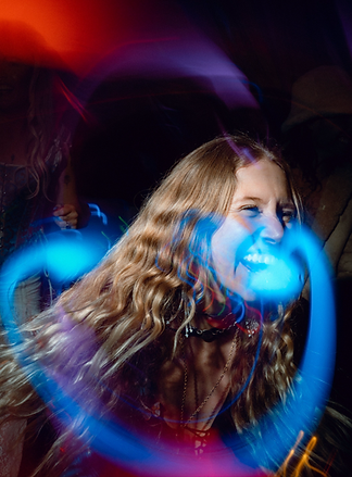 Jess dancing in laser-drenched dancefloor, moving intentionally, embodying presence and connection through movement.