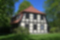 Traditionelles Fachwerkhaus mit weißer Fassade und dunklen Holzstreben