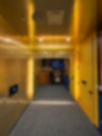 Bright golden hallway with wall graphics leading to an exhibit.