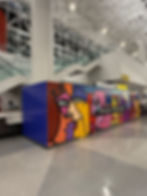 Abstract mural on barricade with 'Find joy in the journey'