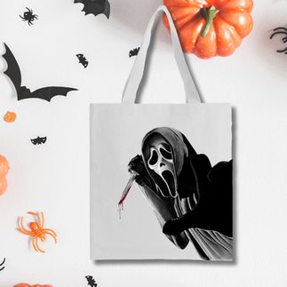 White Tote Bag featuring realism drawing of Ghostface. In the drawing Ghostface is holding up a knife, with blood dripping off and blood platter surrounding it. The tote bags is on a background featuring Halloween elements, including bats, spiders and pumpkins.